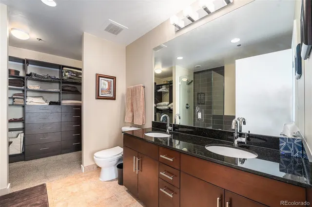 a bathroom with a double vanity sink toilet and shower