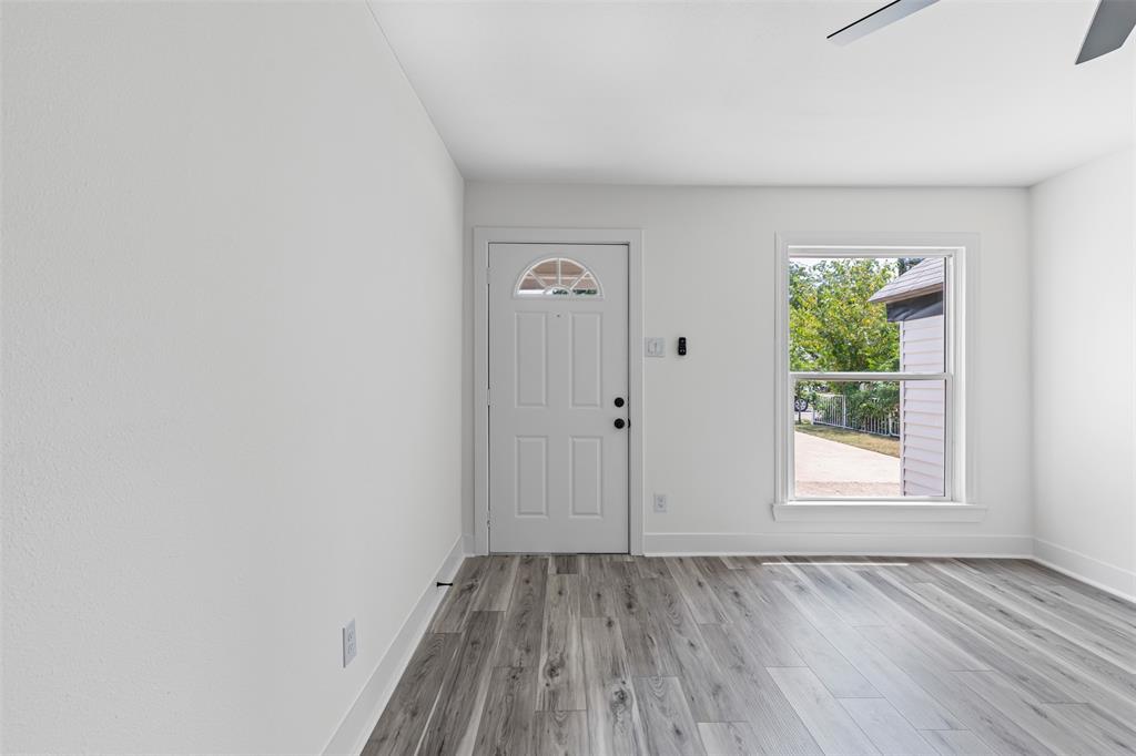 2327 Brookfield Avenue Dallas, TX 75235 - Photo 5 of 31 an empty room with wooden floor and windows