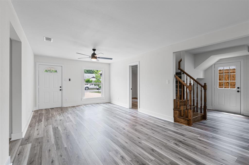 2327 Brookfield Avenue Dallas, TX 75235 - Photo 7 of 31 an empty room with wooden floor a ceiling fan and windows