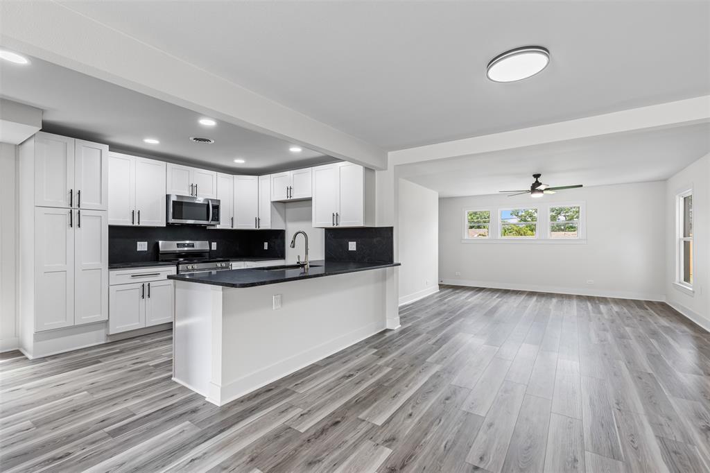2327 Brookfield Avenue Dallas, TX 75235 - Photo 31 of 31 a view of kitchen with stainless steel appliances granite countertop a stove a sink and white cabinets with wooden floor