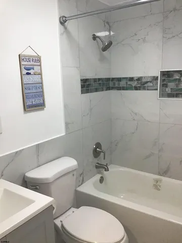 a white toilet sitting next to a bath tub