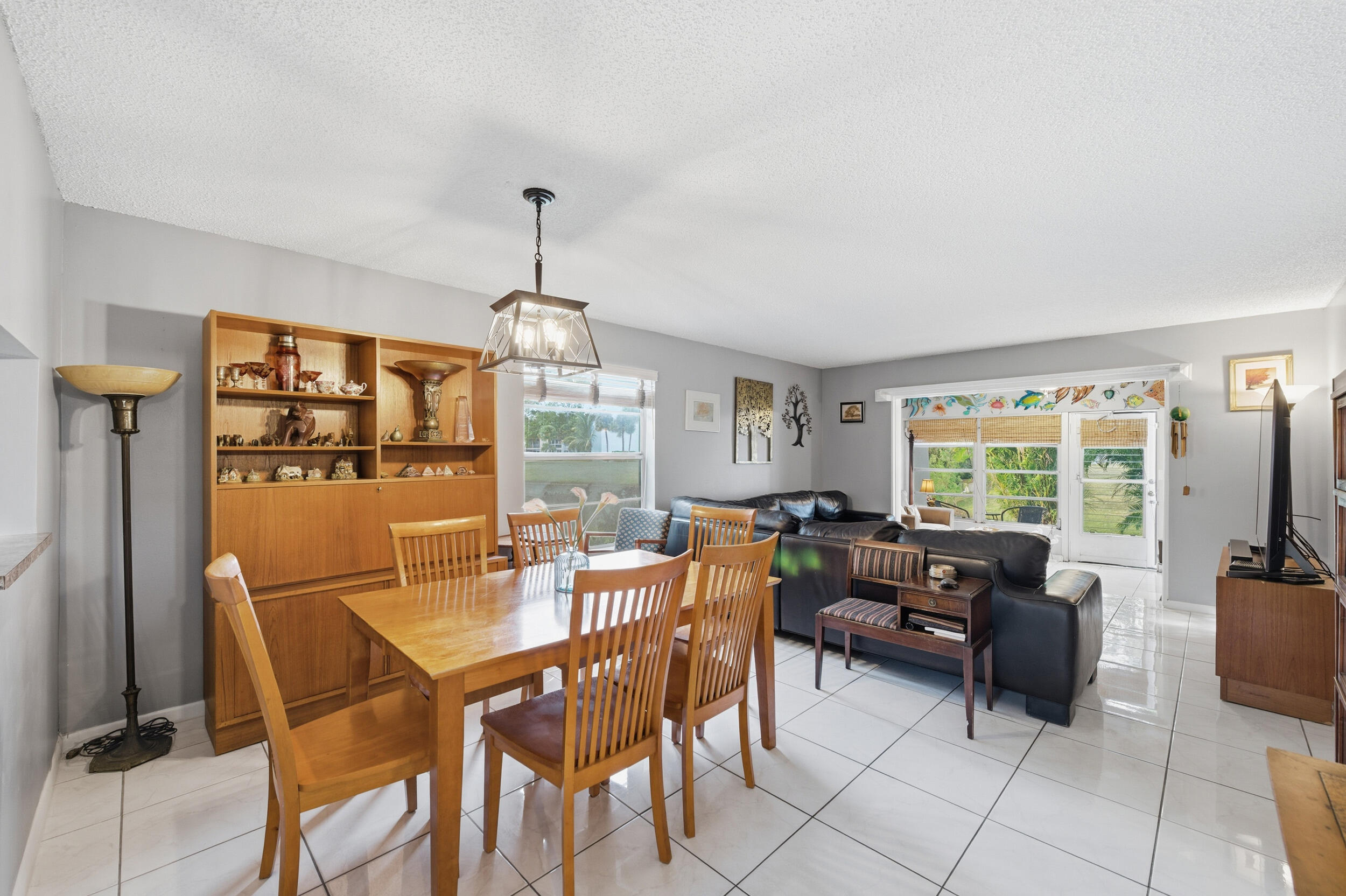 2600 Fiore Way, Unit 101C Delray Beach, FL 33445 - Photo 11 of 40 a dining room with furniture a chandelier and window