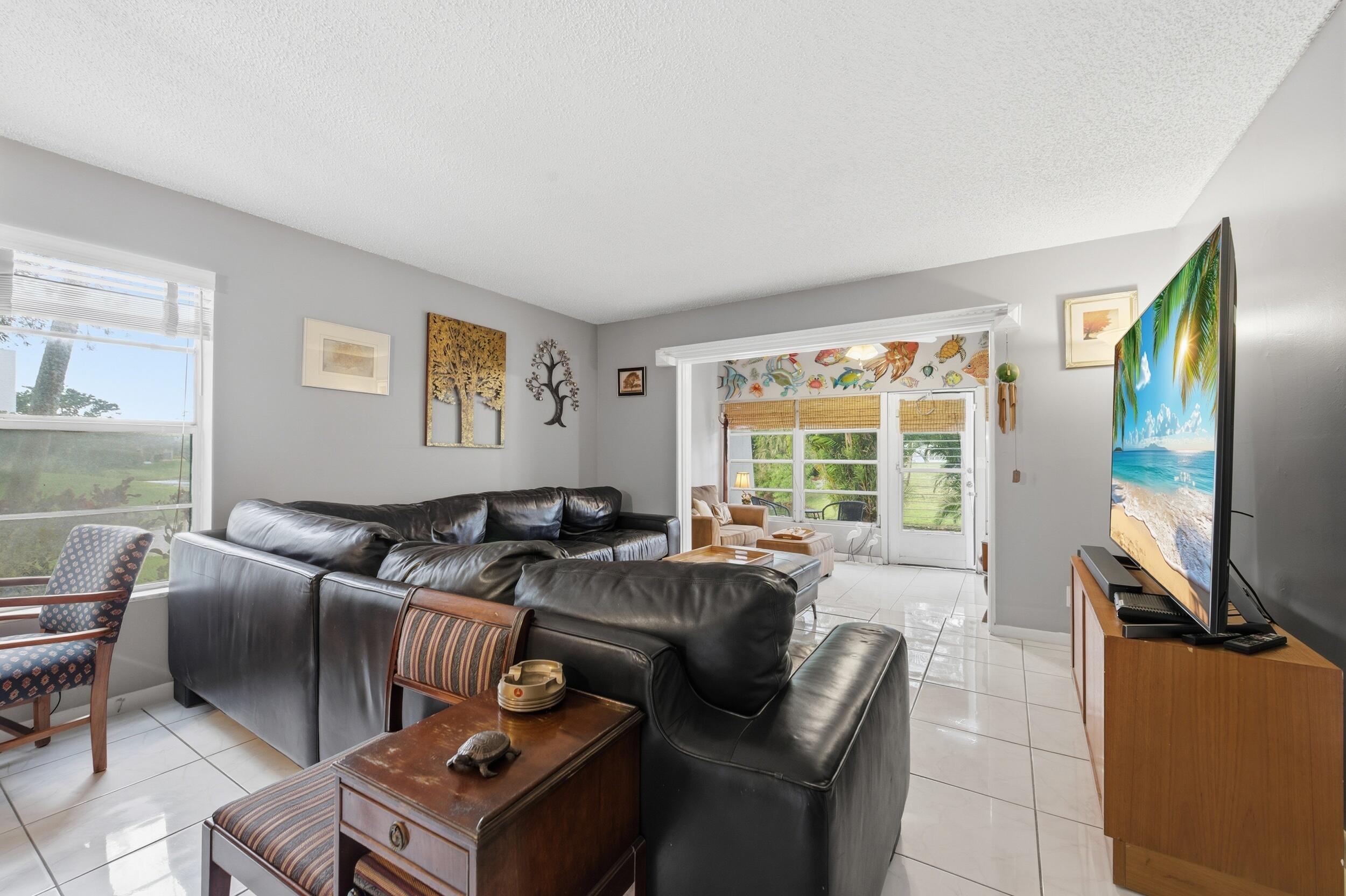 2600 Fiore Way, Unit 101C Delray Beach, FL 33445 - Photo 13 of 40 a living room with furniture and a flat screen tv