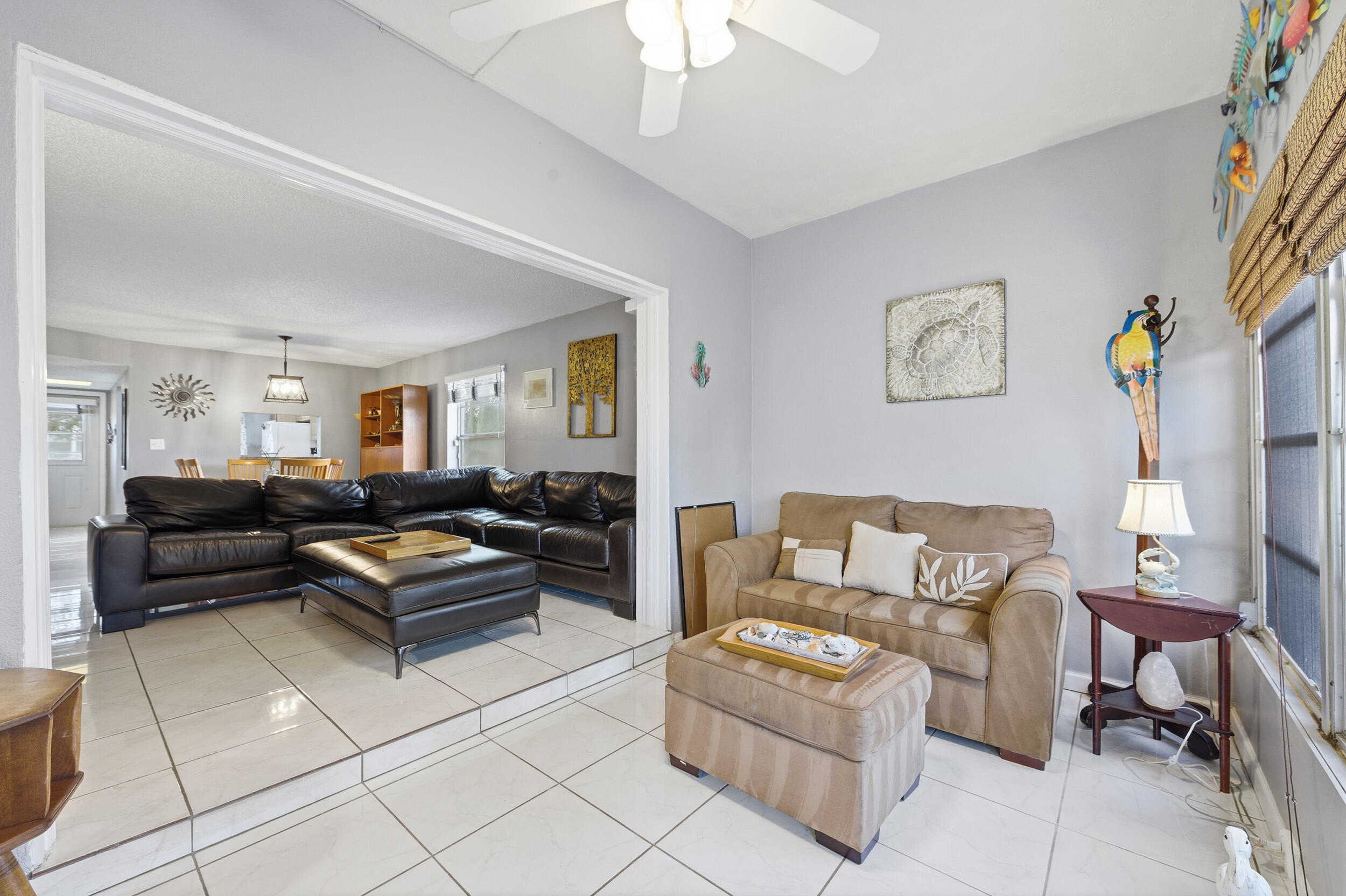 2600 Fiore Way, Unit 101C Delray Beach, FL 33445 - Photo 17 of 40 a living room with furniture and a painting on the wall