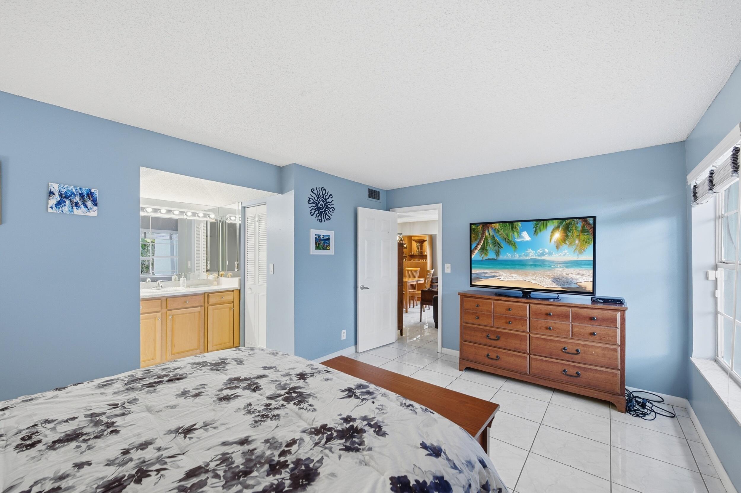 2600 Fiore Way, Unit 101C Delray Beach, FL 33445 - Photo 19 of 40 a bedroom with a bed and dresser