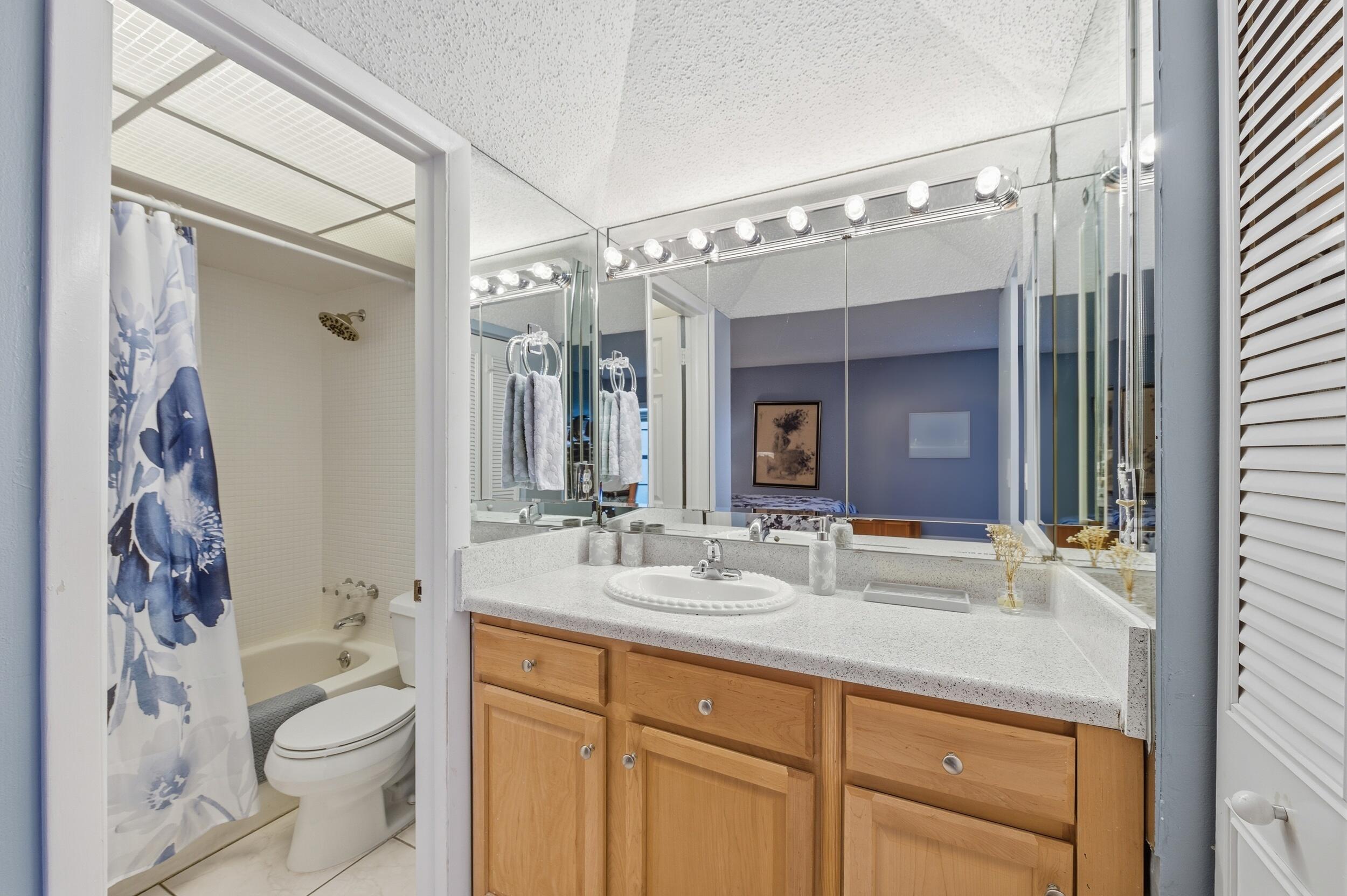 2600 Fiore Way, Unit 101C Delray Beach, FL 33445 - Photo 20 of 40 a bathroom with a granite countertop sink toilet and shower