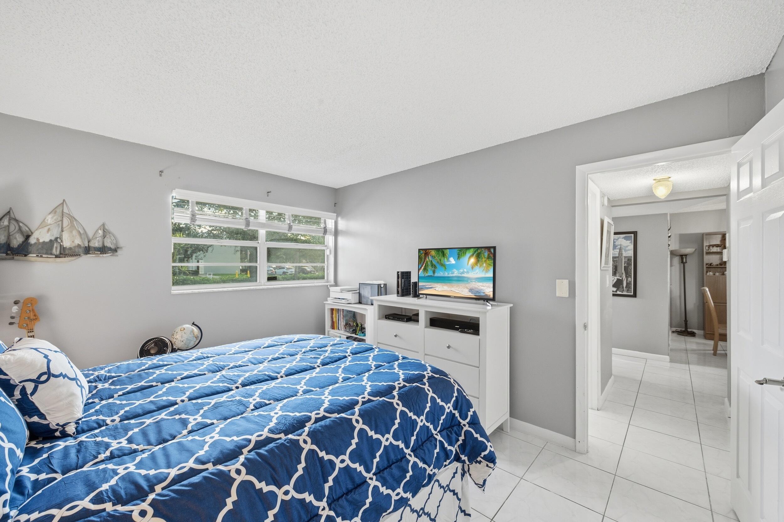 2600 Fiore Way, Unit 101C Delray Beach, FL 33445 - Photo 22 of 40 a bedroom with a large bed and a window
