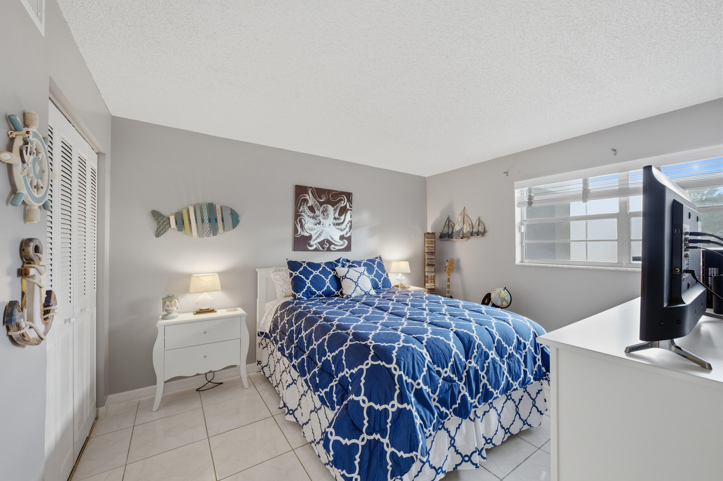 2600 Fiore Way, Unit 101C Delray Beach, FL 33445 - Photo 23 of 40 a bedroom with a bed and wooden floor