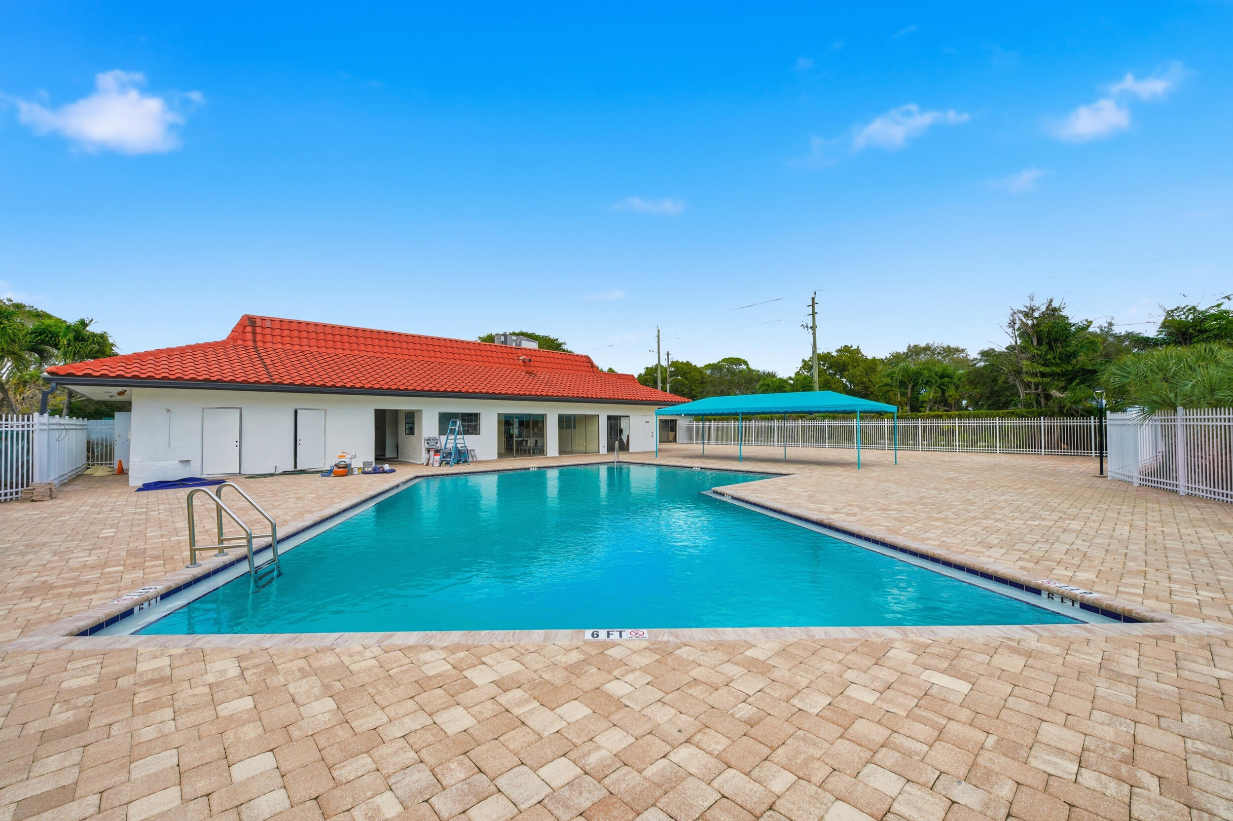 2600 Fiore Way, Unit 101C Delray Beach, FL 33445 - Photo 32 of 40 a view of pool with lawn chairs and large trees