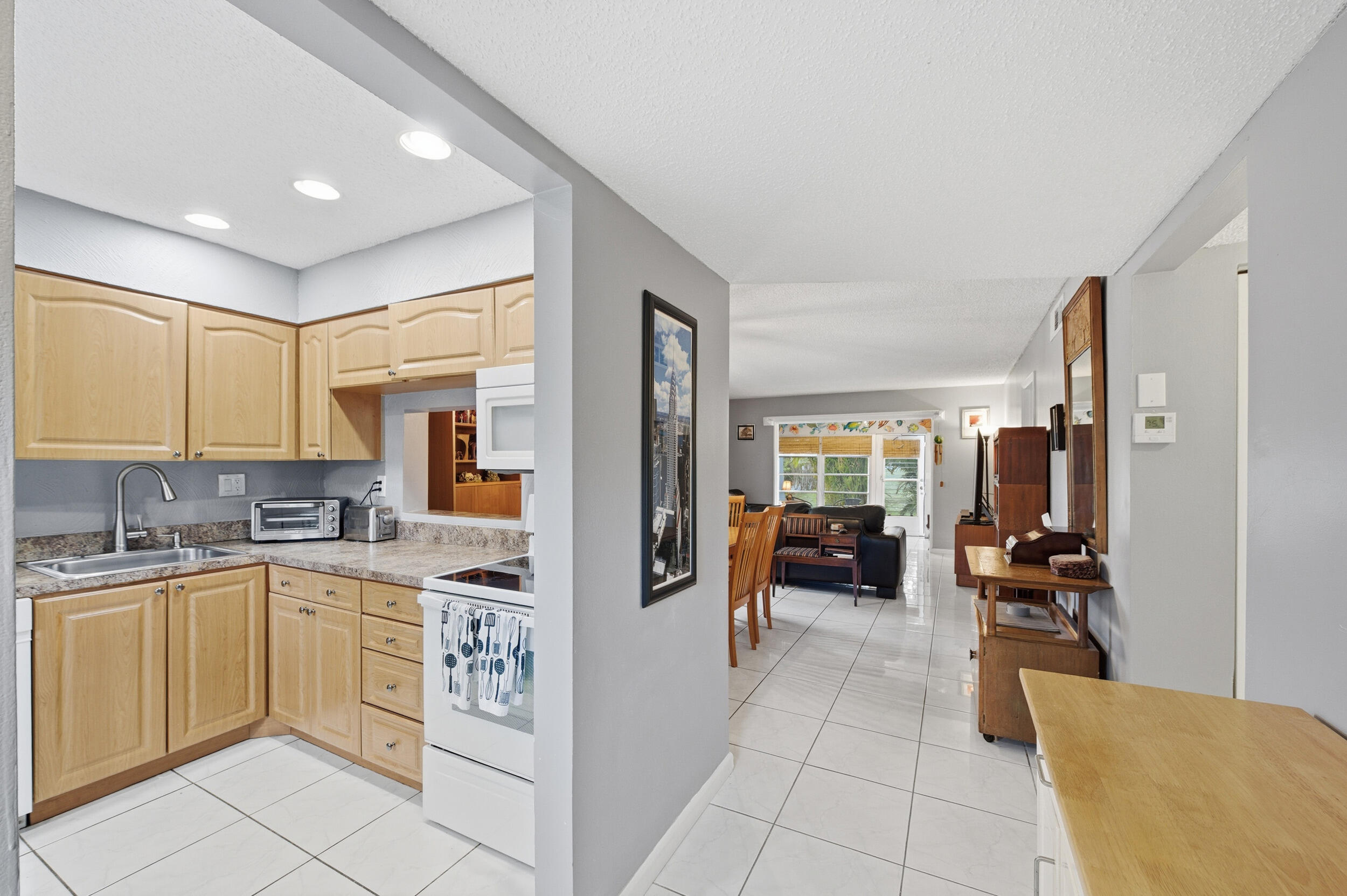 2600 Fiore Way, Unit 101C Delray Beach, FL 33445 - Photo 4 of 40 a kitchen with a sink dishwasher stove and refrigerator