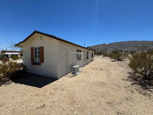 a view of a white house with wooden fence