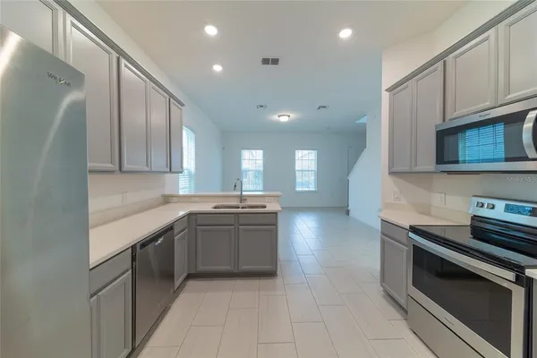 a kitchen with stainless steel appliances granite countertop a stove a sink and a microwave