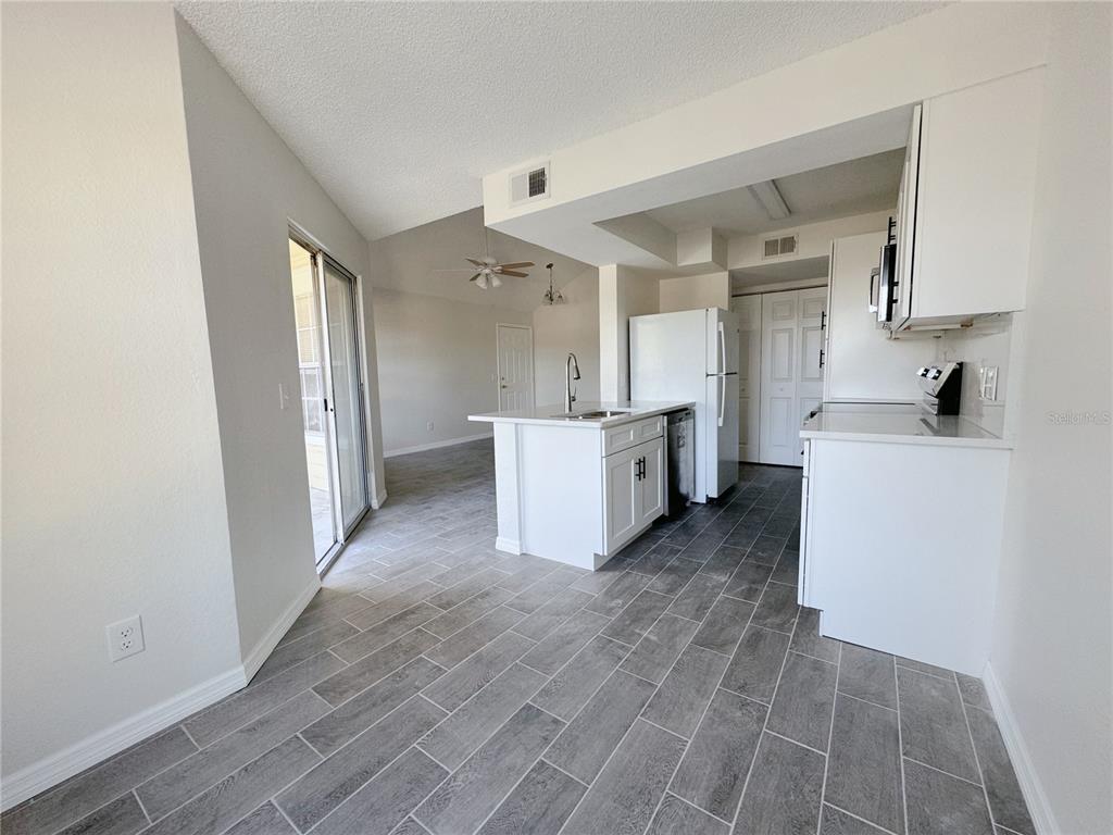 1013 South Hiawassee Road, Unit 3635 Orlando, FL 32835 - Photo 10 of 20 a view of a kitchen with wooden floor and electronic appliances