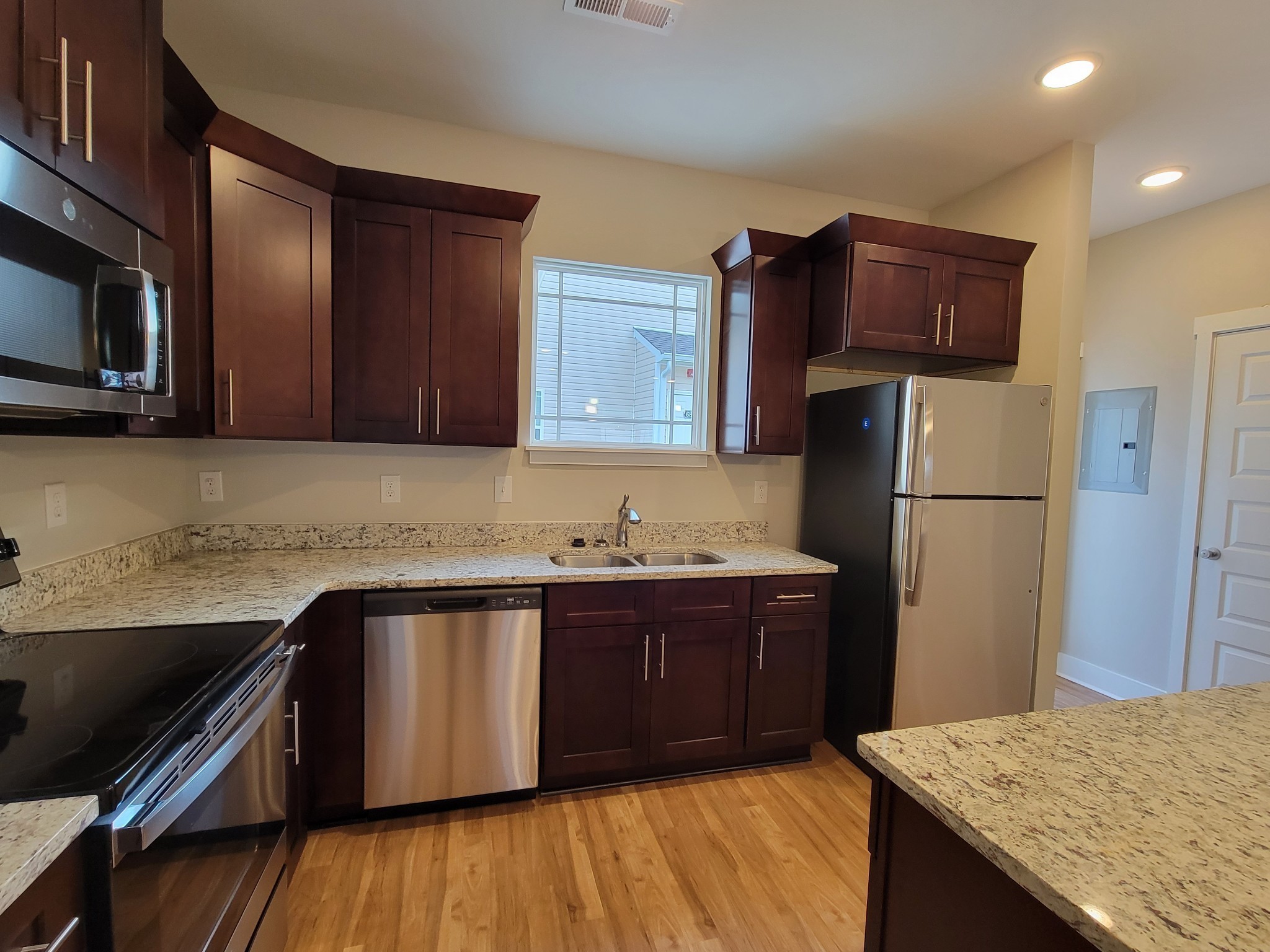 4007 Angelica Ct Spring Hill Spring Hill, TN 37174 - Photo 3 of 16 a kitchen with stainless steel appliances granite countertop a refrigerator a sink dishwasher and wooden cabinets with wooden floor