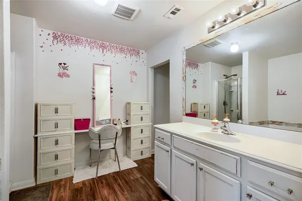 a en suite bathroom with a sink vanity and a mirror