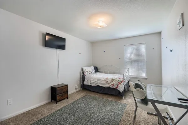 a bedroom with furniture and a flat screen tv