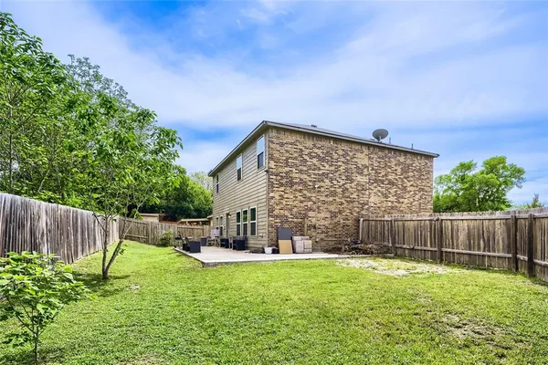 a view of an house with backyard and furniture
