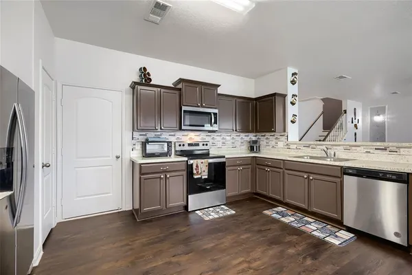a kitchen with stainless steel appliances granite countertop a stove sink and cabinets