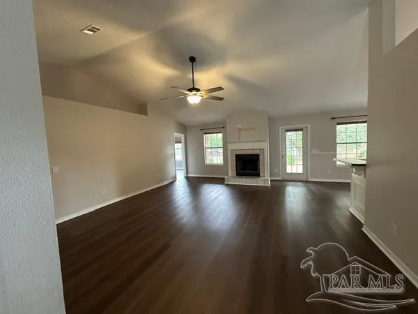 a view of a livingroom with furniture hardwood floor a ceiling fan and a fireplace