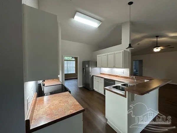a kitchen with stainless steel appliances granite countertop a stove a sink and a microwave