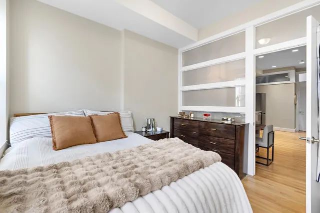 a bedroom with a bed and wooden floor