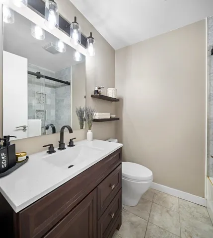 a bathroom with a sink a toilet a mirror and vanity