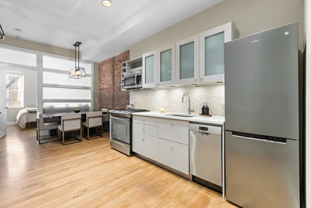 a kitchen with stainless steel appliances granite countertop a refrigerator and a stove top oven