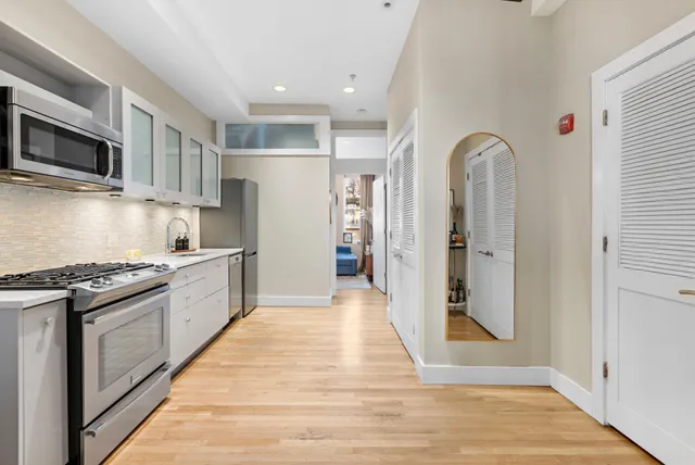 a large kitchen with stainless steel appliances granite countertop a stove and a refrigerator