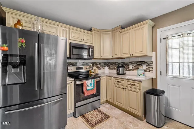 a kitchen with stainless steel appliances granite countertop a refrigerator stove and sink