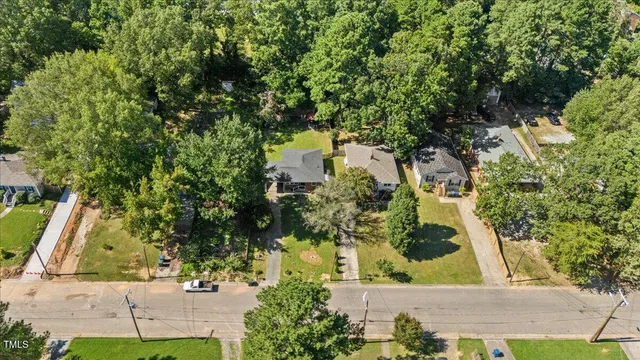 an aerial view of a house with a yard and large trees
