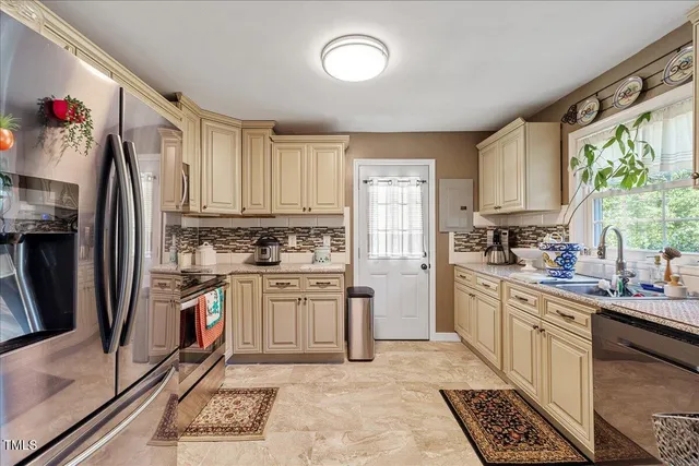 a kitchen with stainless steel appliances granite countertop a refrigerator sink and stove