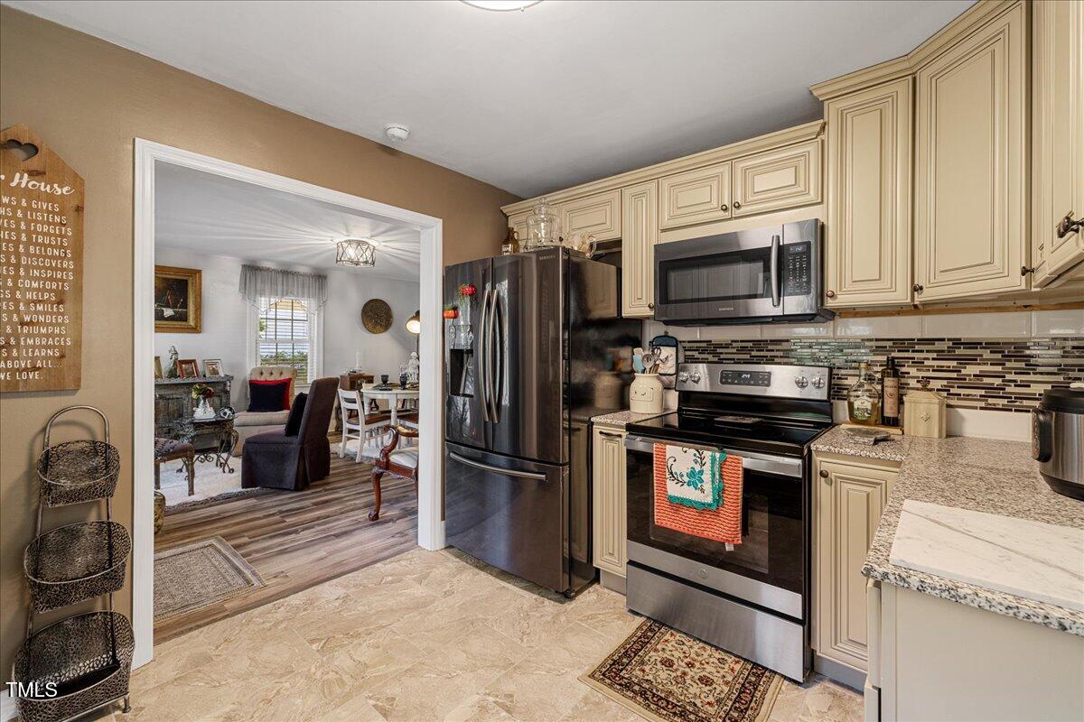 415 Edward Street Durham, NC 27701 - Photo 9 of 27 a kitchen with stainless steel appliances a stove a sink and a refrigerator