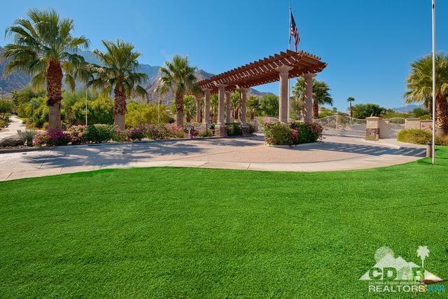 1255 Palmas Ridge Palm Springs, CA 92262 - Photo 31 of 34 a view of a yard with a table and chairs under an umbrella