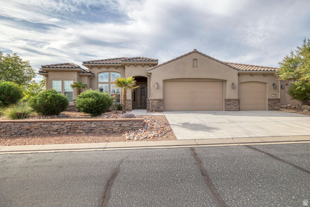 2109 Vision Point Street, Unit 1037 St. George, UT 84790 - Photo 1 of 1 Mediterranean / spanish-style house with stone siding, a garage, driveway, and stucco siding