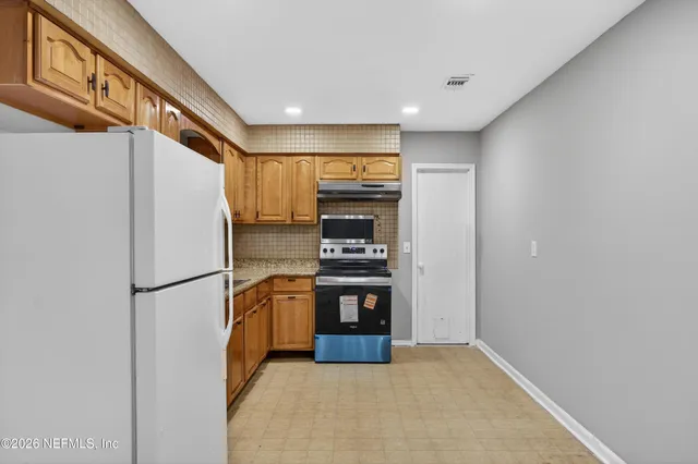 a kitchen with stainless steel appliances a refrigerator and a stove top oven