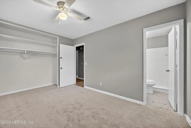 a view of a room with a ceiling fan and bathroom