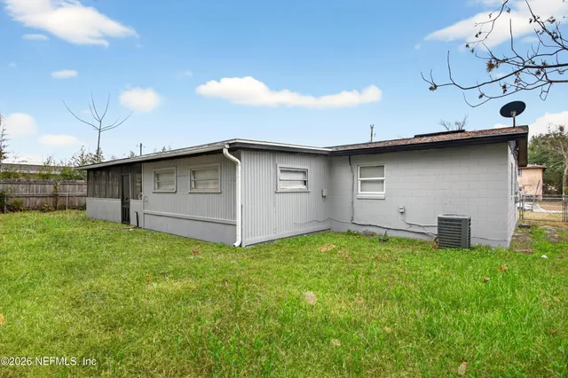 a view of a backyard with plants and a grill