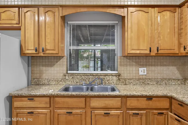 a kitchen with granite countertop cabinets and window
