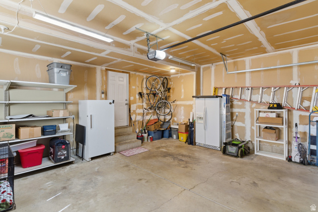 134 West 475 South Ogden, UT 84404 - Photo 25 of 27 Garage with white refrigerator with ice dispenser, freestanding refrigerator, and a garage door opener