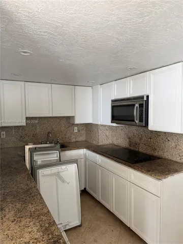 a kitchen with stainless steel appliances granite countertop a sink and a microwave