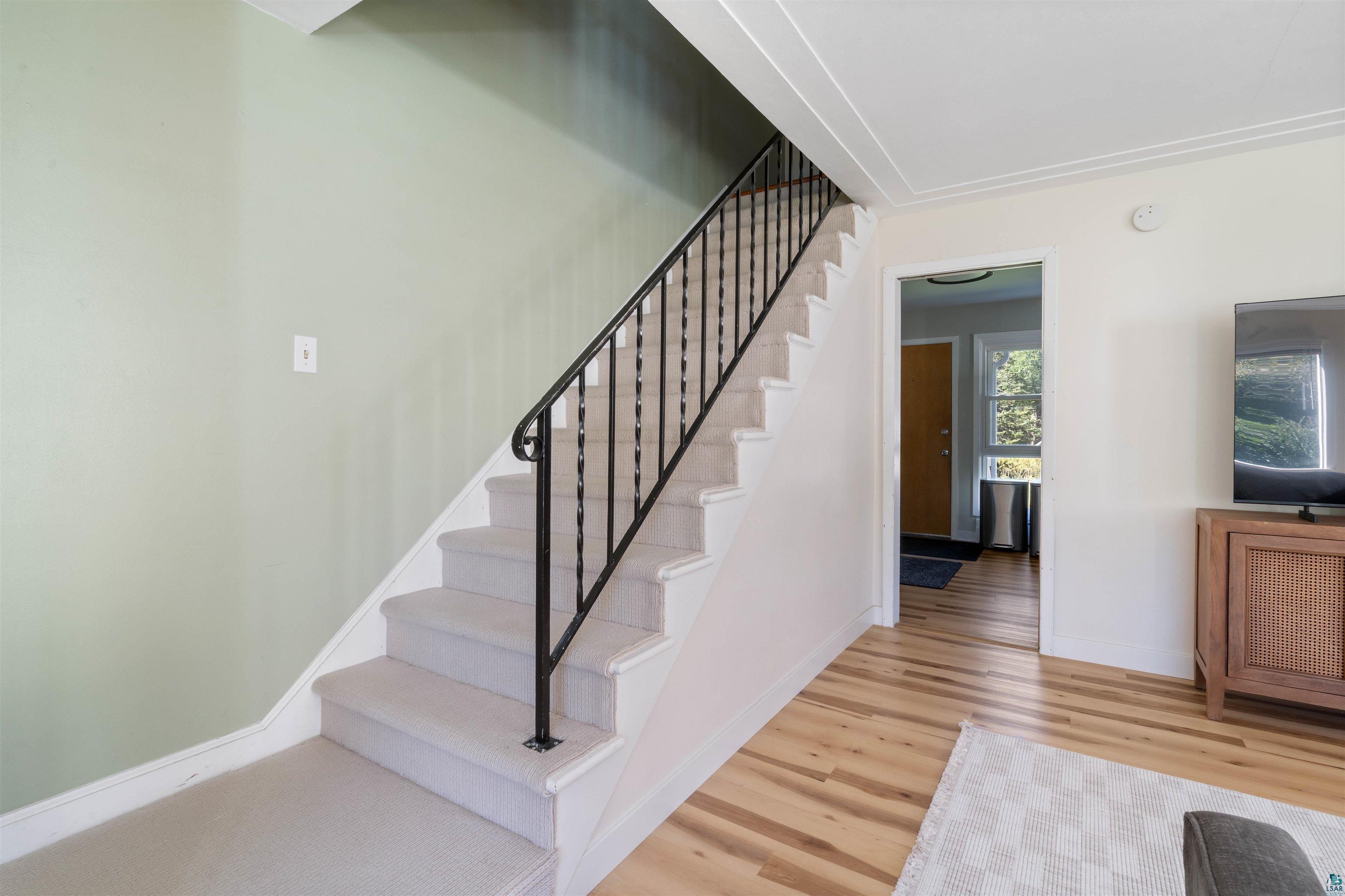 3715 Rendle Avenue Duluth, MN 55803 - Photo 13 of 20 Carpeted staircase with wrought iron railing