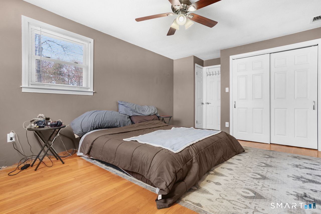 111 Ione Drive Meriden, CT 06450 - Photo 11 of 37 a bedroom with a bed and a chandelier
