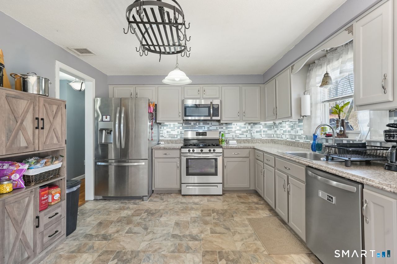 111 Ione Drive Meriden, CT 06450 - Photo 6 of 37 a kitchen with stainless steel appliances a refrigerator sink and cabinets