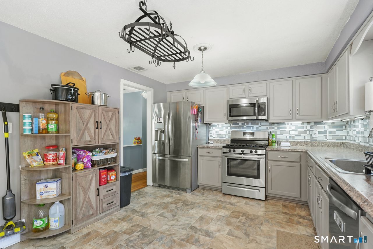 111 Ione Drive Meriden, CT 06450 - Photo 7 of 37 a kitchen with stainless steel appliances granite countertop a sink and a refrigerator