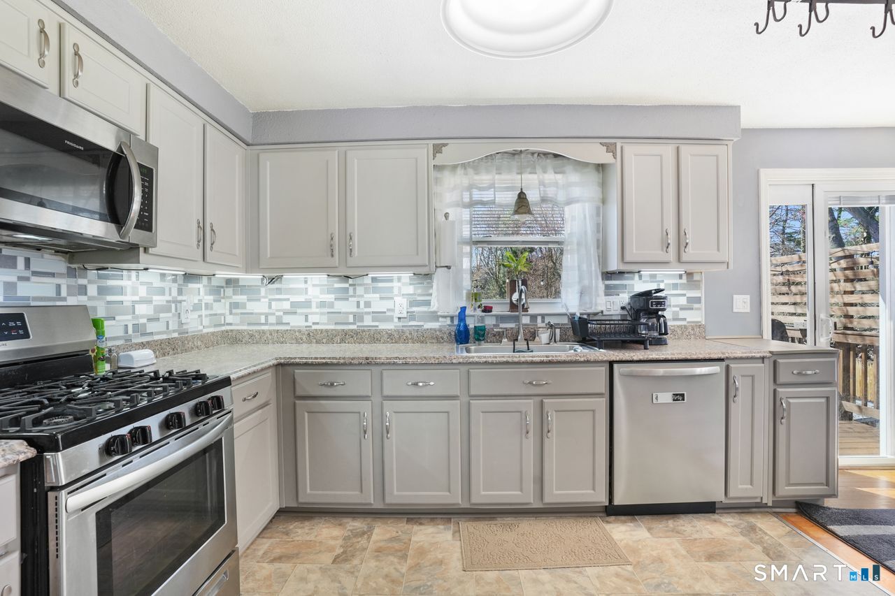 111 Ione Drive Meriden, CT 06450 - Photo 8 of 37 a kitchen with granite countertop white cabinets stainless steel appliances and a sink