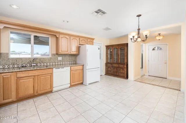 a kitchen with granite countertop white cabinets and white appliances
