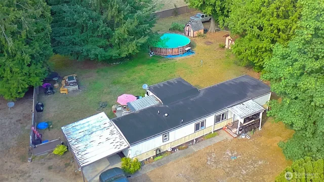 an aerial view of a house with swimming pool and outdoor seating