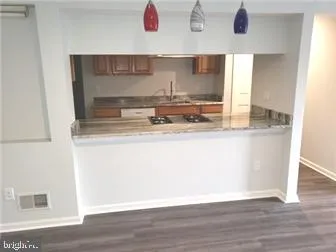 a kitchen with kitchen island stainless steel appliances a sink and wooden floor