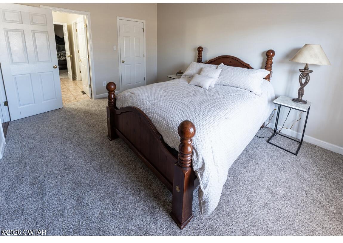 9 Shadow Ridge Drive Jackson, TN 38305 - Photo 13 of 25 a bed room with a bed and a chandelier