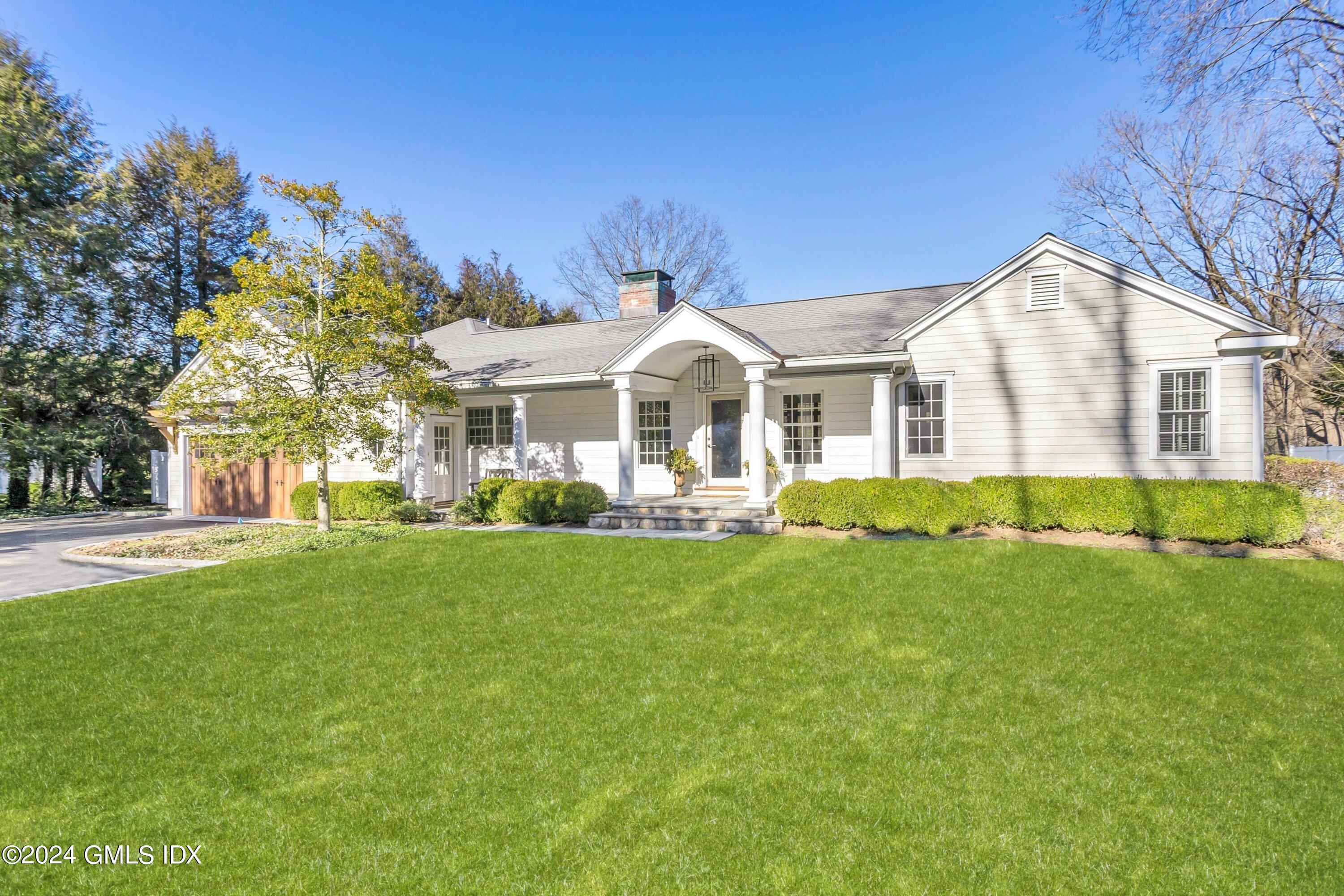71 Fairfield Road Greenwich, CT 06830 - Photo 3 of 24 a front view of a house with a yard and trees